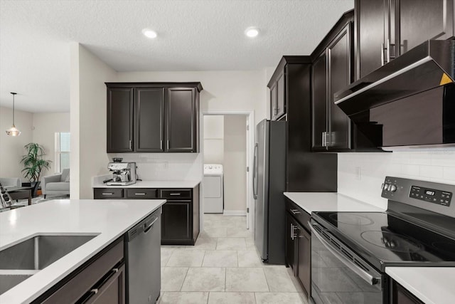 kitchen with under cabinet range hood, tasteful backsplash, washer / clothes dryer, and appliances with stainless steel finishes