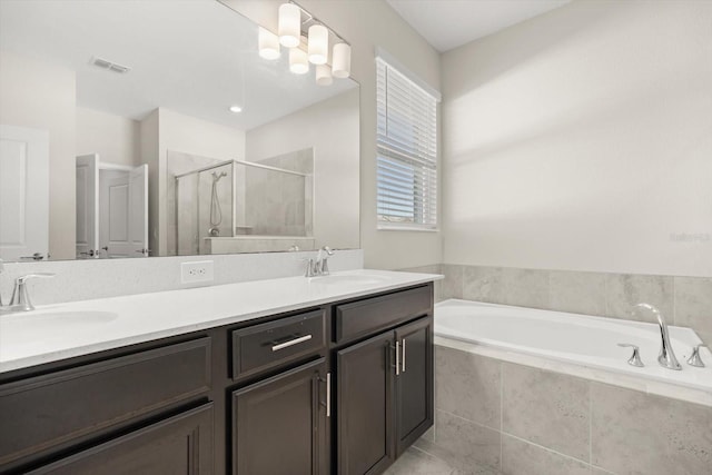 full bathroom featuring visible vents, a stall shower, double vanity, and a sink