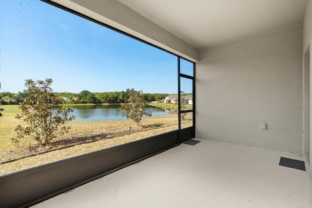 unfurnished sunroom featuring a water view