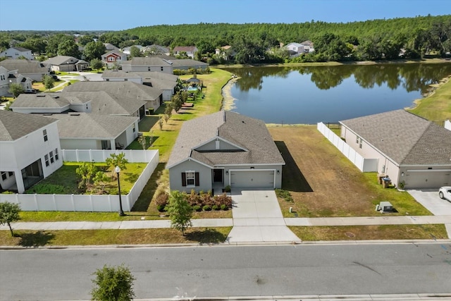 drone / aerial view with a residential view, a water view, and a view of trees
