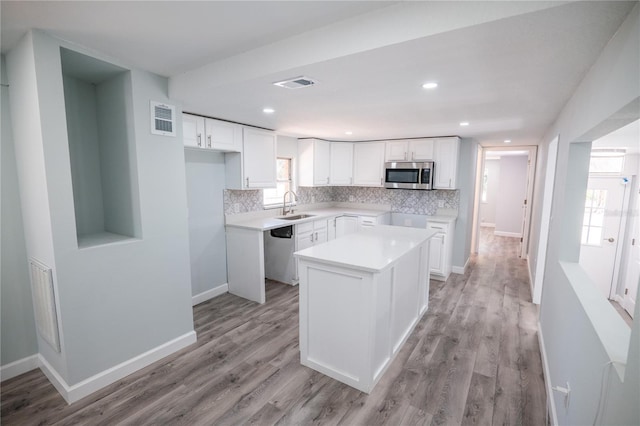 kitchen featuring visible vents, a sink, tasteful backsplash, and stainless steel appliances
