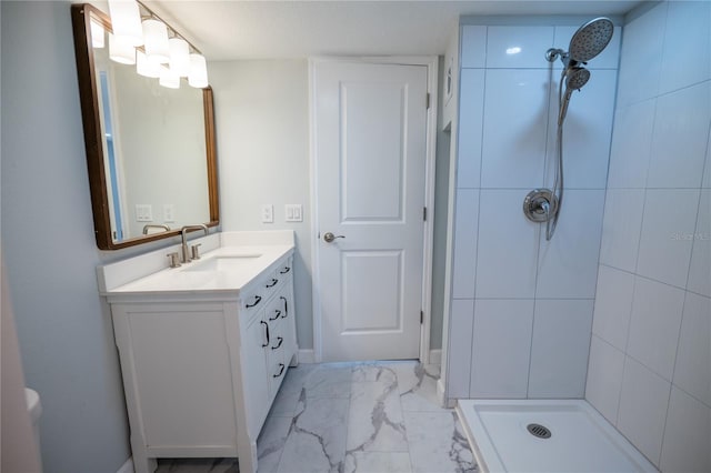 bathroom with vanity, marble finish floor, and a tile shower