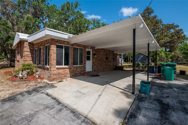 view of patio with concrete driveway and a carport