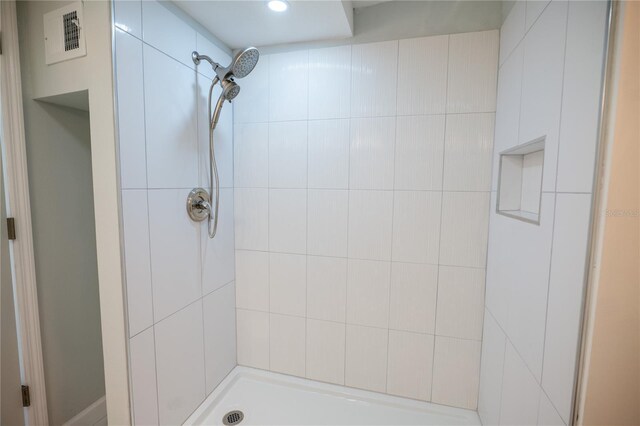 bathroom featuring visible vents and a tile shower