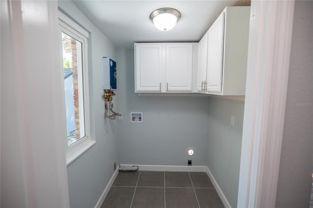 laundry area with plenty of natural light, washer hookup, cabinet space, and dark tile patterned flooring