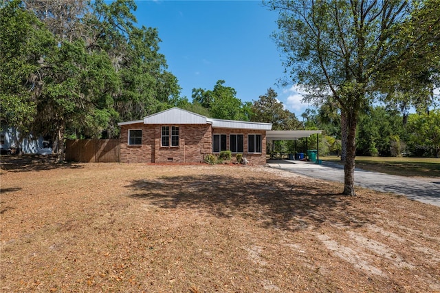ranch-style home with crawl space, brick siding, fence, concrete driveway, and an attached carport