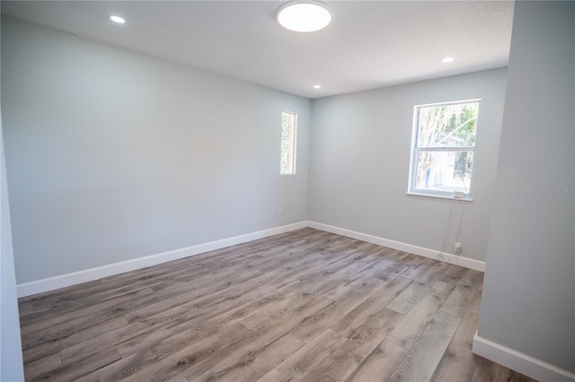 unfurnished room featuring recessed lighting, baseboards, and wood finished floors