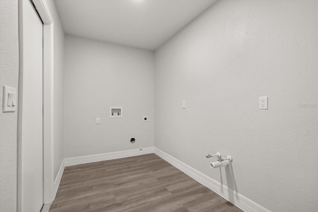 washroom with hookup for an electric dryer, hookup for a gas dryer, washer hookup, laundry area, and wood finished floors