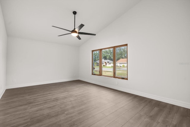 spare room featuring dark wood-style flooring, a ceiling fan, high vaulted ceiling, and baseboards