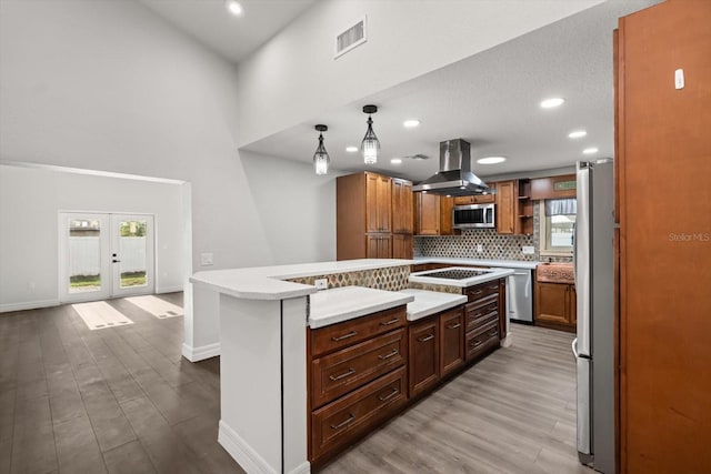 kitchen featuring appliances with stainless steel finishes, island range hood, visible vents, baseboards, and wood finished floors