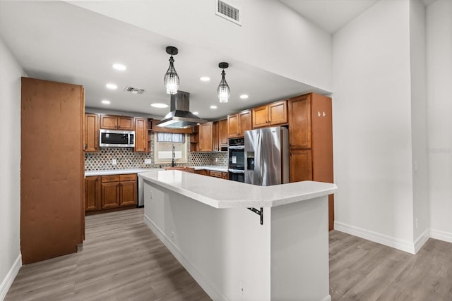 kitchen with light wood-style floors, island exhaust hood, visible vents, baseboards, and appliances with stainless steel finishes