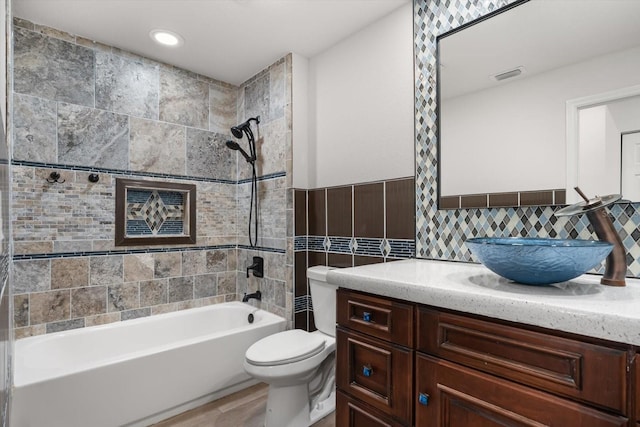 full bath featuring shower / tub combination, visible vents, toilet, tile walls, and vanity
