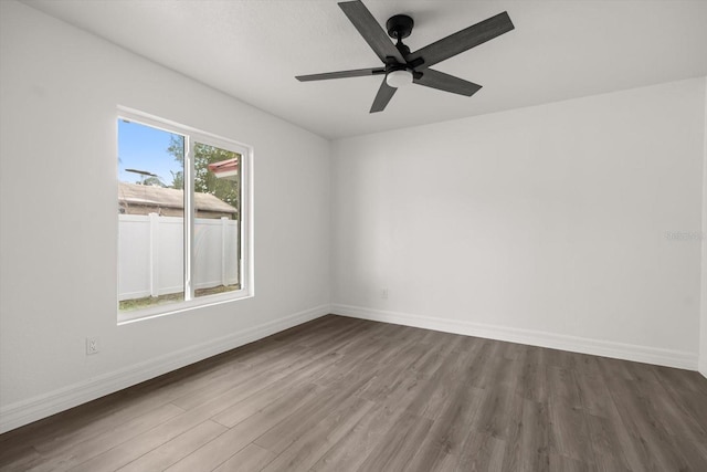 unfurnished room featuring baseboards, wood finished floors, and ceiling fan
