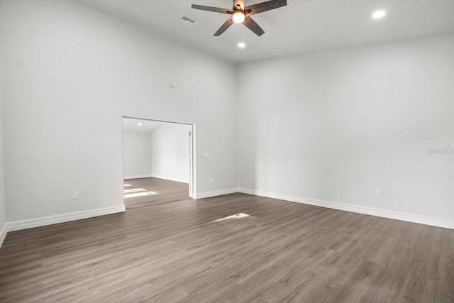 spare room with visible vents, ceiling fan, dark wood finished floors, and baseboards