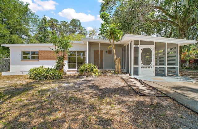 rear view of property with a sunroom