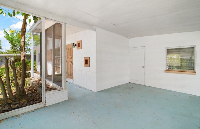 exterior space featuring concrete block siding and a patio area