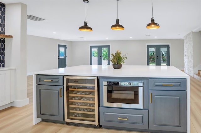 40 W Laurel St, Apopka, FL 32703 - bar with pendant lighting, light wood-style floors, french doors, and beverage cooler
