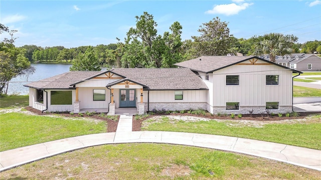40 W Laurel St, Apopka, FL 32703 - modern farmhouse style home featuring stone siding, a water view, a shingled roof, a front yard, and french doors
