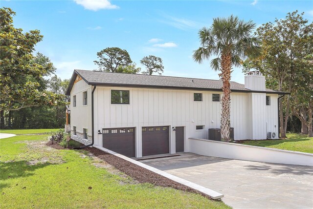 40 W Laurel St, Apopka, FL 32703 - view of front facade featuring a garage, a chimney, a front lawn, and driveway