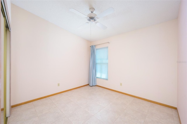 empty room with baseboards and a ceiling fan