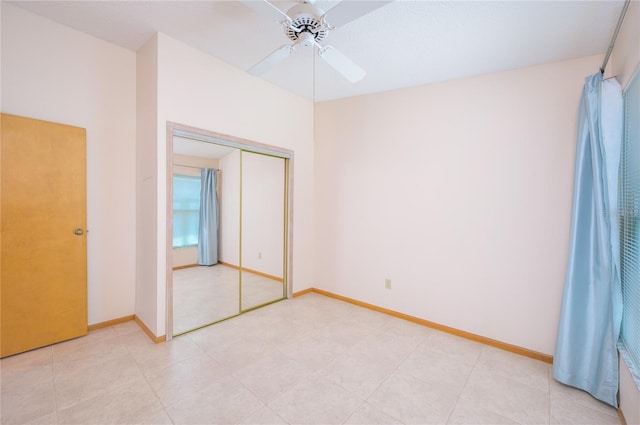 unfurnished bedroom with a closet, baseboards, and ceiling fan