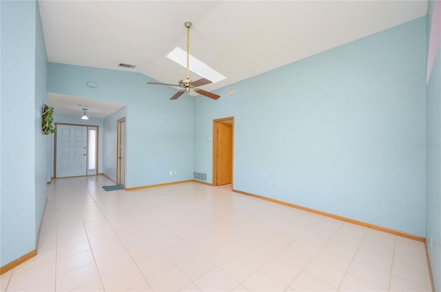 spare room with vaulted ceiling with skylight, baseboards, a ceiling fan, and visible vents