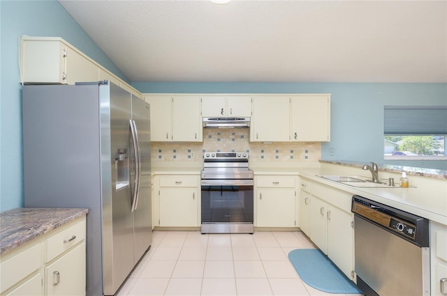 kitchen with decorative backsplash, light countertops, a sink, appliances with stainless steel finishes, and exhaust hood