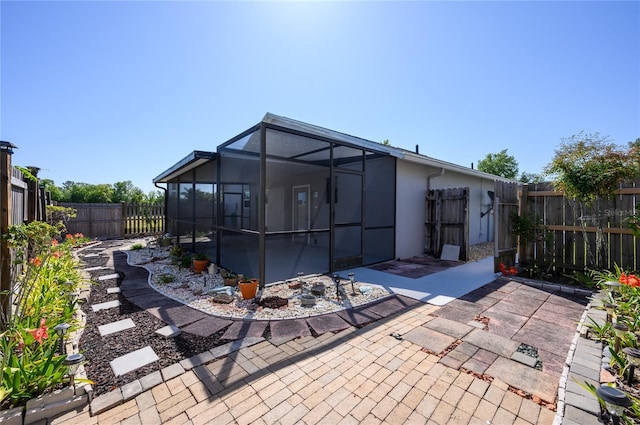 rear view of property featuring a patio, a fenced backyard, and stucco siding