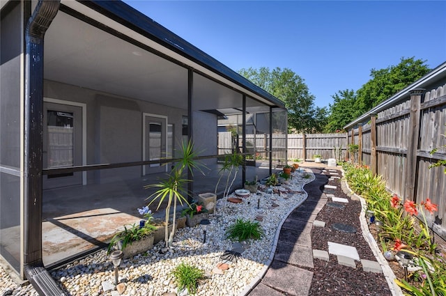 view of yard featuring a fenced backyard and a sunroom