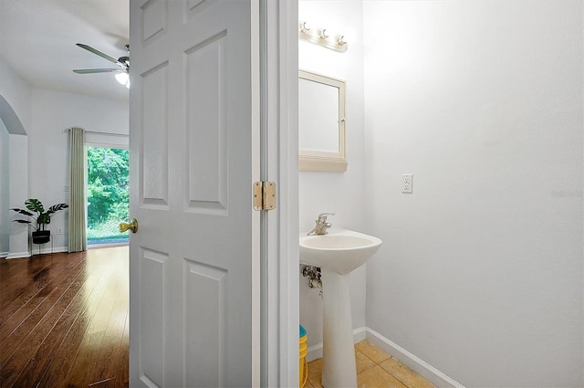 bathroom with baseboards, wood finished floors, ceiling fan, and a sink