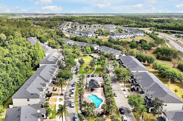 drone / aerial view featuring a residential view and a forest view