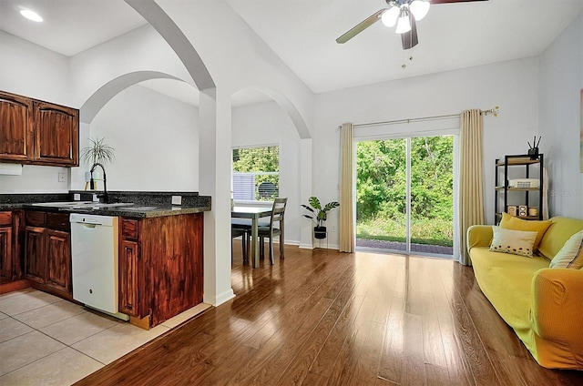 kitchen featuring light wood finished floors, a sink, ceiling fan, dishwasher, and open floor plan