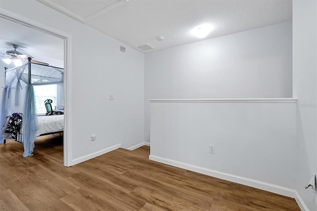 unfurnished bedroom with baseboards, visible vents, and wood finished floors