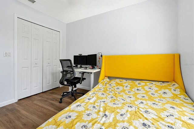 bedroom with wood finished floors and a closet