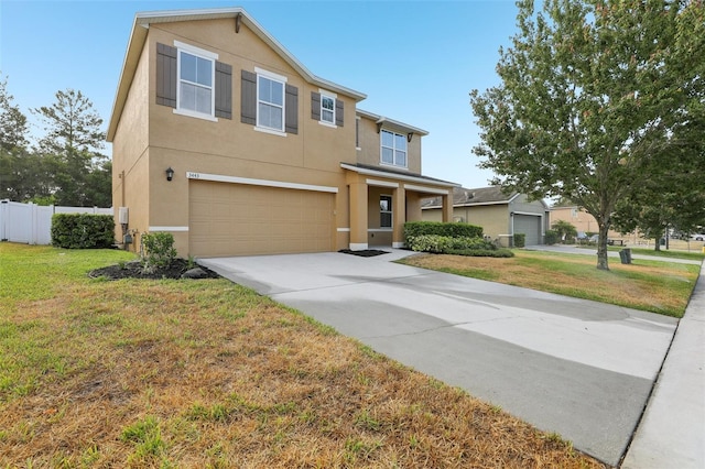 traditional home with stucco siding, fence, a front lawn, and a garage