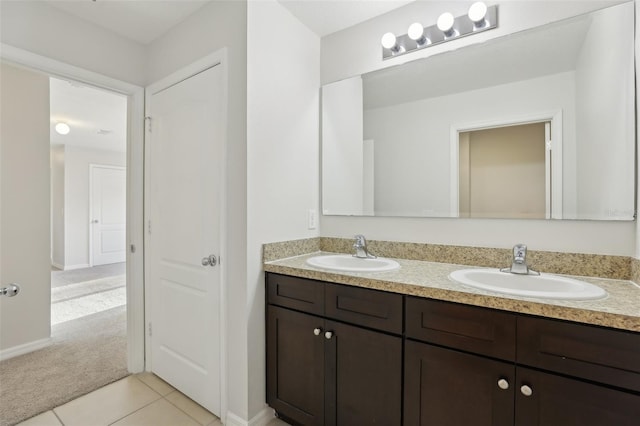 bathroom featuring a sink, tile patterned floors, baseboards, and double vanity