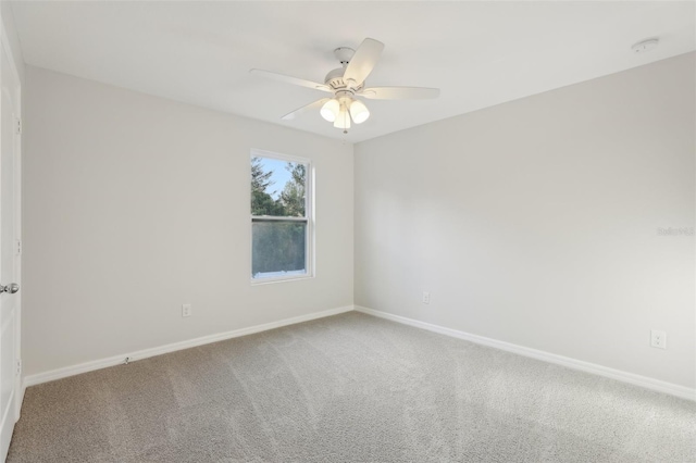 unfurnished room with a ceiling fan, baseboards, and carpet
