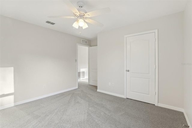 unfurnished bedroom with baseboards, carpet, a ceiling fan, and visible vents