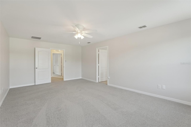 carpeted empty room with ceiling fan, visible vents, and baseboards