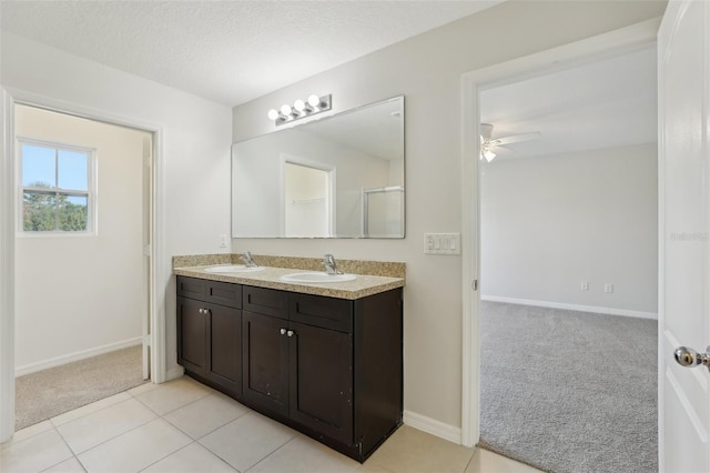 bathroom with double vanity, a ceiling fan, baseboards, and a sink