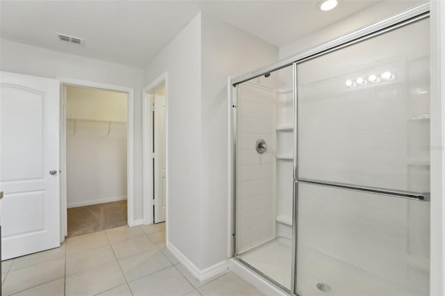 bathroom featuring visible vents, tile patterned floors, baseboards, a shower stall, and a spacious closet