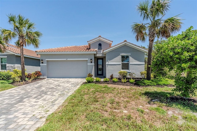 507 Daylily Blvd, Nokomis, FL 34275 - view of front of home with an attached garage, decorative driveway, a tiled roof, and stucco siding