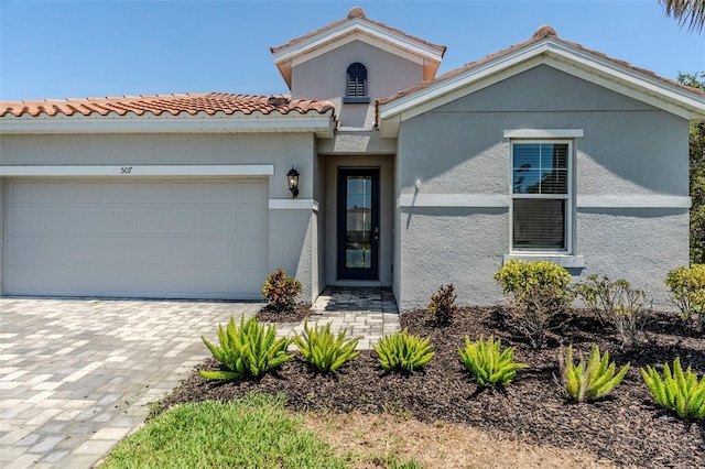 507 Daylily Blvd, Nokomis, FL 34275 - mediterranean / spanish-style house featuring a garage, stucco siding, a tiled roof, and decorative driveway