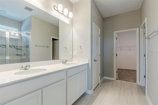 507 Daylily Blvd, Nokomis, FL 34275 - bathroom featuring a shower stall, a walk in closet, double vanity, and baseboards