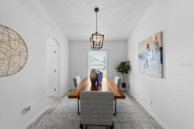 119 Argyle Gate Loop Rd, Dundee, FL 33838 - dining room featuring wood finished floors, baseboards, arched walkways, vaulted ceiling, and a chandelier