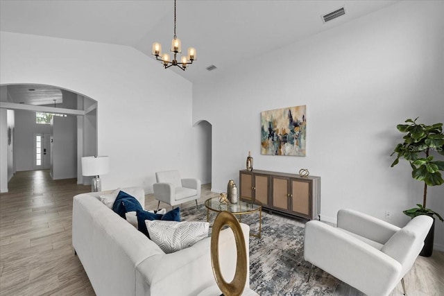 119 Argyle Gate Loop Rd, Dundee, FL 33838 - living room with arched walkways, a chandelier, lofted ceiling, and light wood-style flooring
