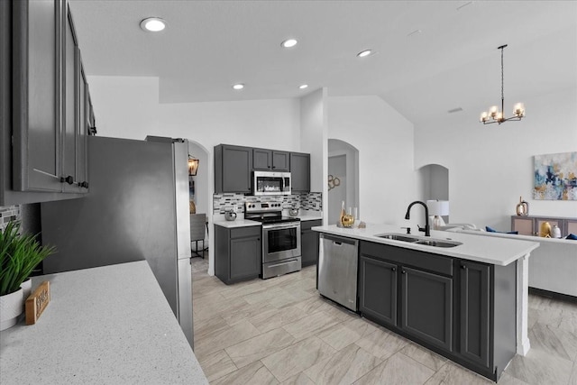 119 Argyle Gate Loop Rd, Dundee, FL 33838 - kitchen with stainless steel appliances, arched walkways, a sink, vaulted ceiling, and a chandelier