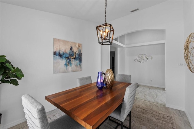 119 Argyle Gate Loop Rd, Dundee, FL 33838 - dining room with a chandelier, arched walkways, and baseboards