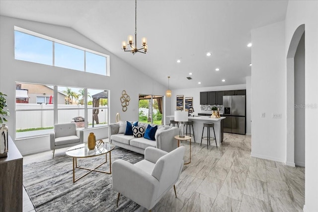 119 Argyle Gate Loop Rd, Dundee, FL 33838 - living area featuring arched walkways, light marble finish floors, high vaulted ceiling, a chandelier, and recessed lighting