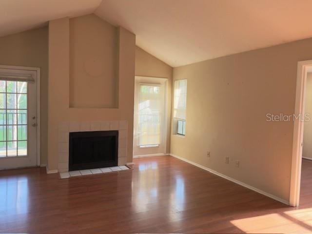 208 Afton Sq Unit 307, Altamonte Springs, FL 32714 - unfurnished living room with vaulted ceiling, wood finished floors, baseboards, and a tile fireplace